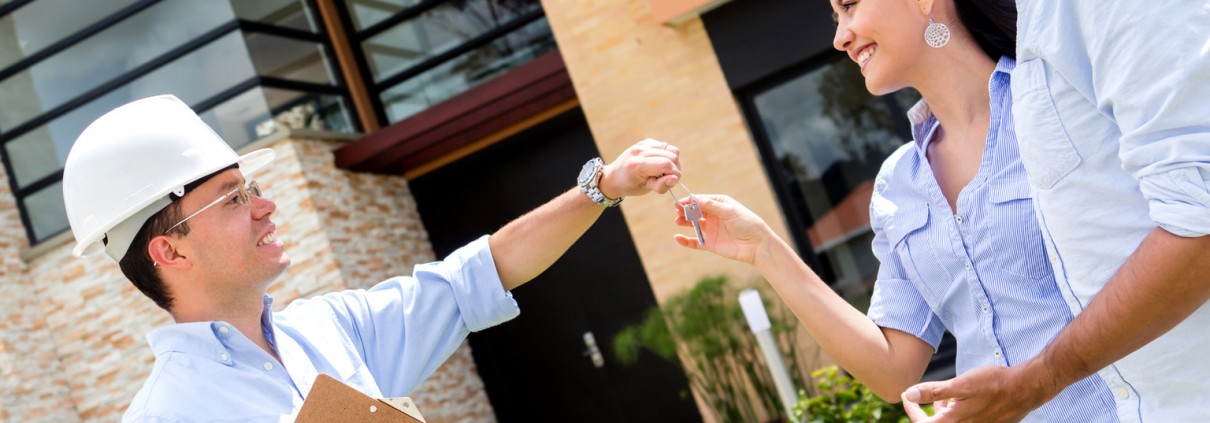 Architect handling keys of their new house to a couple